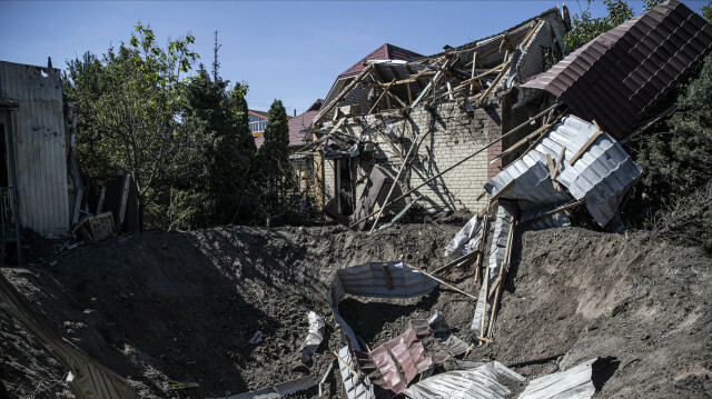 A Ukrainian soldier inspects near a bomb crater at the scene after Russian shell hit a school building last night as the Russian-Ukraine war continues on June 27, 2022, in Shevchenkivs'kyi district of Kharkiv, Ukraine.