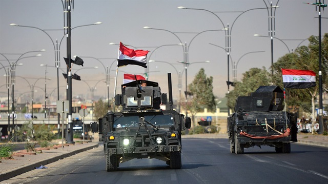 Iraqi security forces advance in military vehicles in Kirkuk, Iraq.