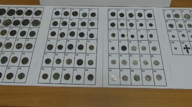 Operasyonda ele geçirilen 106 adet sikke ve 1 adet haç şeklinde kolye ucu.
