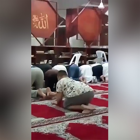 Down sendromlu çocuk secdedeki adamın ayağını gıdıklarsa