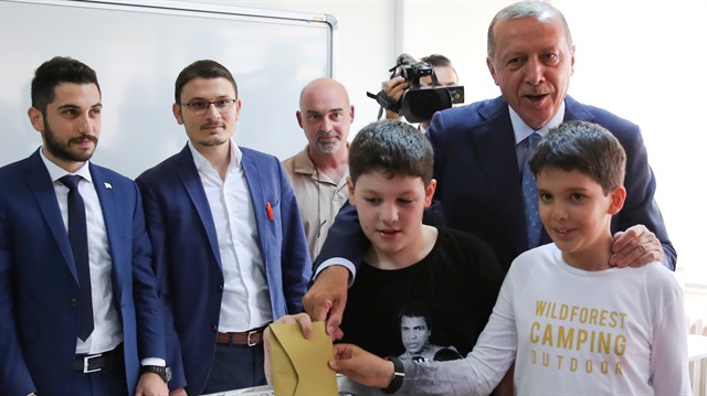 Turkish President Tayyip Erdoğan, accompanied by his grandchildren, casts his ballot at a polling station in Istanbul, Turkey June 24, 2018. 