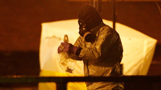  Members of the emergency services wearing protective clothing work 
