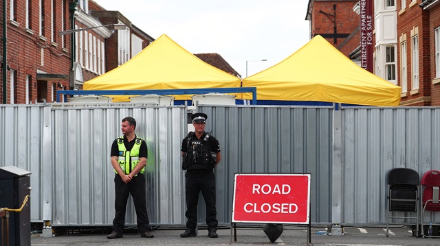 Police officers stand outside the street where Dawn Sturgess lived before dying after being exposed to a Novichok nerve agent, in Salisbury, Britain.