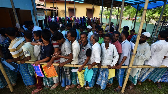 People wait in queue to check their names on the draft list at the National Register of Citizens (NRC) centre at a village in Nagaon district, Assam state, India