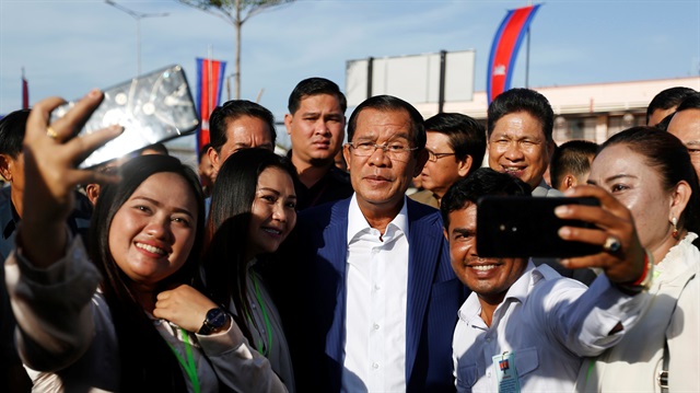Supporters take pictures with Cambodia's Prime Minister Hun Sen (C) as he attends an inauguration of a new boat terminal in Phnom Penh, Cambodia.