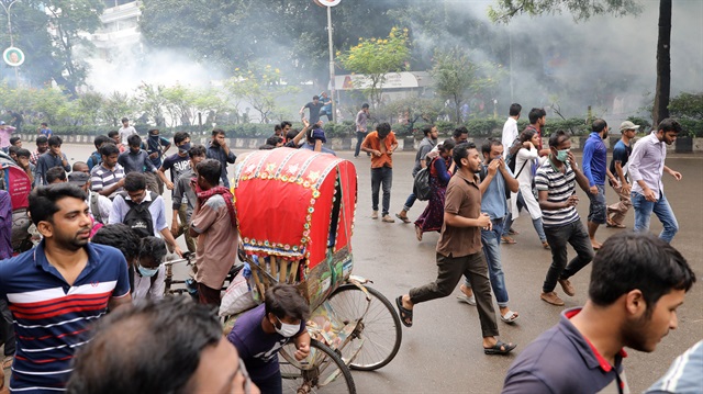 People and students run as police fire tear gas shells during a protest over recent traffic accidents that killed a boy and a girl, in Dhaka, Bangladesh.
