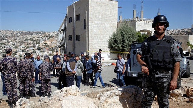 Security forces gather near a damaged building at the city of Salt, Jordan