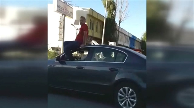 Otomobil tavanında oturarak araç kullanan maganda kamerada