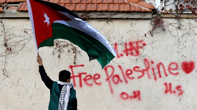 File photo: A boy holds the Jordanian national flag during a protest near the U.S. Embassy in Amman, Jordan 