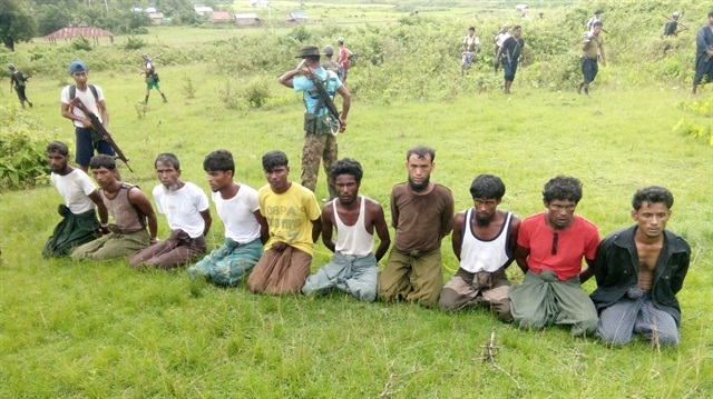 : Ten Rohingya Muslim men with their hands bound kneel