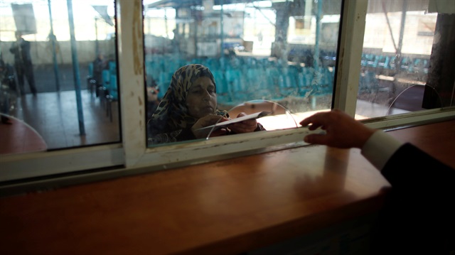 A Palestinian woman presents her document at Erez crossing 