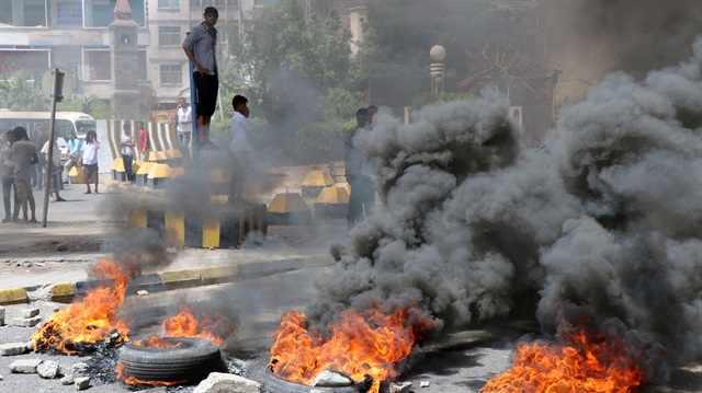 Protesters block a street with burning tires after the Yemeni Riyal has severely plunged against foreign currencies, in Aden, Yemen September 2, 2018. 