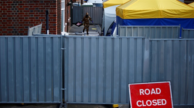  A forensic investigator, wearing a protective suit