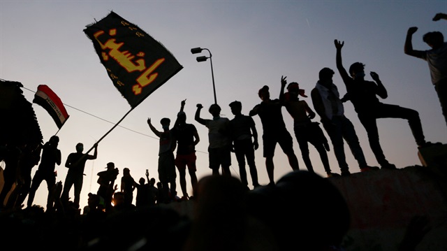 Iraqi protesters stand on concrete blast walls during a protest near the building of the government office in Basra, Iraq September 5, 2018. 