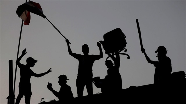 Iraqi protesters stand on concrete blast walls during an anti-government protest near the building of the government office in Basra, Iraq September 7, 2018. 
