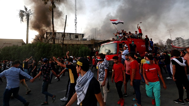 Iraqi protesters stand on a fire truck during an anti-government protest 