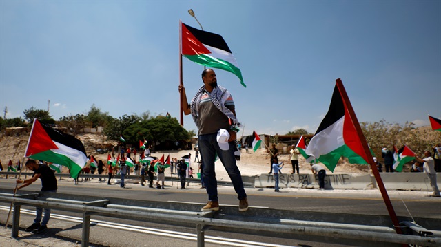 A demonstrator holds a Palestinian flag during a rally in support of Khan al-Ahmar 