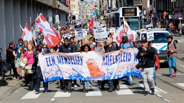 Dam Meydanı'nda toplanan, 'insancıl bir göç politikası' ve 'insanlara kapıyı aç, sermayeye değil' yazılı pankartlar taşıyan göstericiler, 'sınırsız dayanışma', 'önce insan hakları', 'Herkese kapımız açık', 'sınırları aç' ve 'ırkçılığa yer yok' yazılı dövizlerle Museumplein Meydanı'na yürüdü. (Fotoğraf: AA)