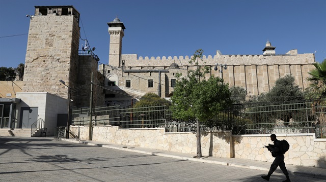 An Israeli soldier walks past Ibrahimi Mosque, which Jews call the Jewish Tomb of the Patriarchs, in the West Bank city of Hebron.