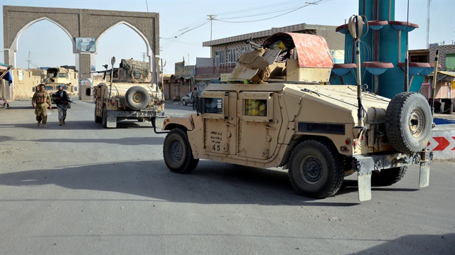 Afghan security guards walk during a Taliban attack in Ghazni city, Afghanistan August 12, 2018. 