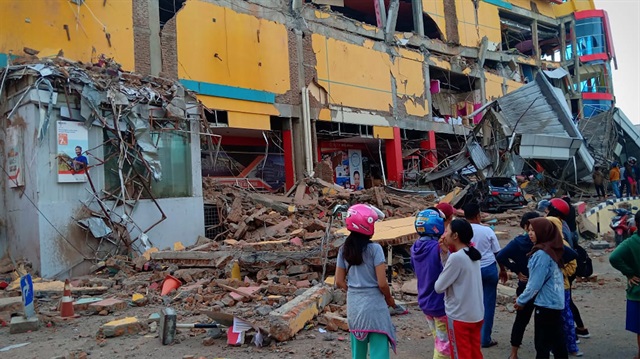 Residents stand in front of a damaged shopping mall after an earthquake hit Palu, Sulawesi Island, Indonesia September 29, 2018. 