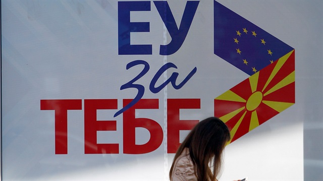 A woman passes next to posters reading "EU for you" for the referendum in Macedonia on changing the country's name that would open the way for it to join NATO and the European Union, in Skopje, Macedonia September 28, 2018. 
