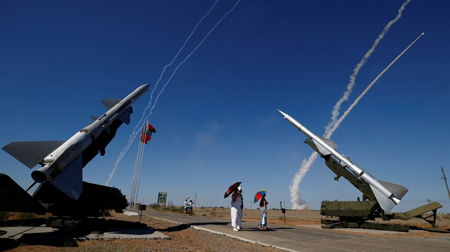 People watch S-300 air defense missile systems launching missiles during the Keys to the Sky competition at the International Army Games 2017 at the Ashuluk shooting range outside Astrakhan, Russia, August 5, 2017. 