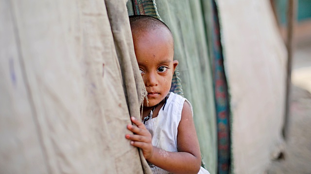 A girl from the Rohingya community stands outside her family's shack in a camp in New Delhi, India, October 4, 2018. 