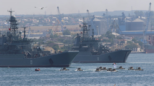 Amphibious vehicles drive in formation past the Russian large landing ships Azov and Caesar Kunikov during a rehearsal for the Navy Day parade in the Black Sea port of Sevastopol, Crimea, July 27, 2017. 