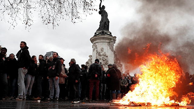 A trash bin burns as youths and high school students attend a demonstration to protest against the French government's reform plan, in Paris, France, December 7, 2018. 