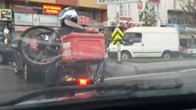 İlginç görüntü: Motosikletinin üzerine koli bandı ile bisiklet sabitledi