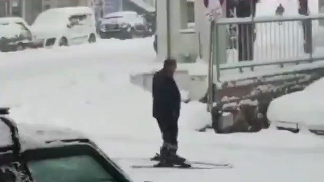 Yağan karı fırsat bilen adam yola kayak takımıyla çıktı