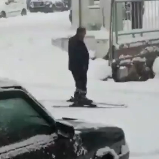 Yağan karı fırsat bilen adam yola kayak takımıyla çıktı