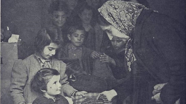 Suriyeli kadınların Yunan çocuklara kıyafet dağıttığı fotoğraf