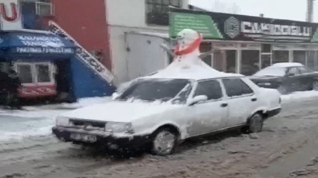 Otomobilinin üzerine kardan adam yapıp trafiğe çıktı