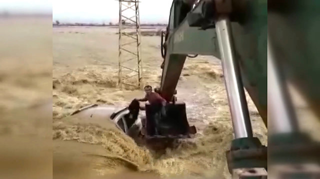 Sel sularına gömülen araçtan kepçeyle kurtarıldılar