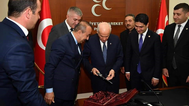 Bahçeli, kendisine hediye edilen tabancayı inceledi.