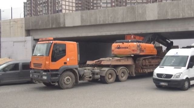 TIR, üstündeki iş makinesi ile köprüye takıldı
