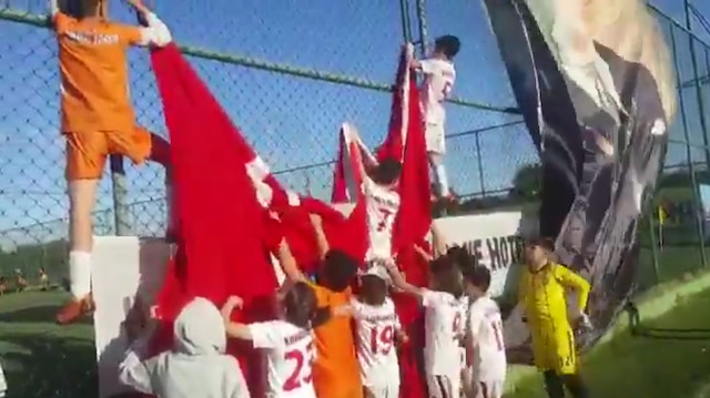 Minik futbolcular yere düşen bayrağı hep birlikte yerine astı