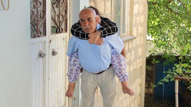 63 yaşındaki Abdullah Örün, hasta kızını sırtında taşıyor.