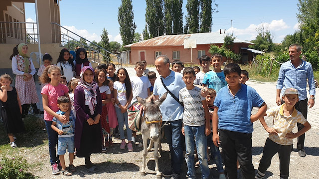 Ersin Bilge ve kitap hediye ettiği çocuklar.