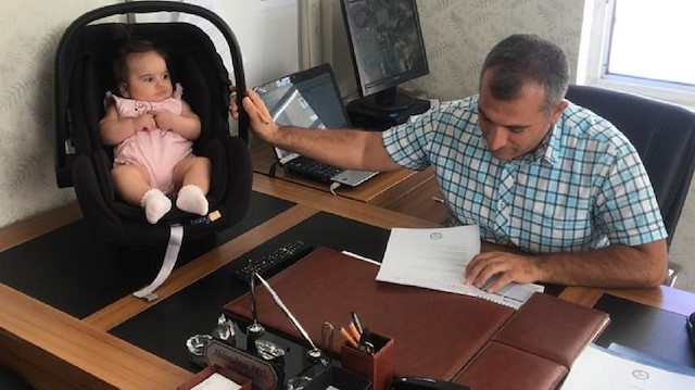 Okul müdürü Arsu, odasında bir yandan minik Deniz'e bakarken, bir yandan da okulun idari işlerini yürütüyor.