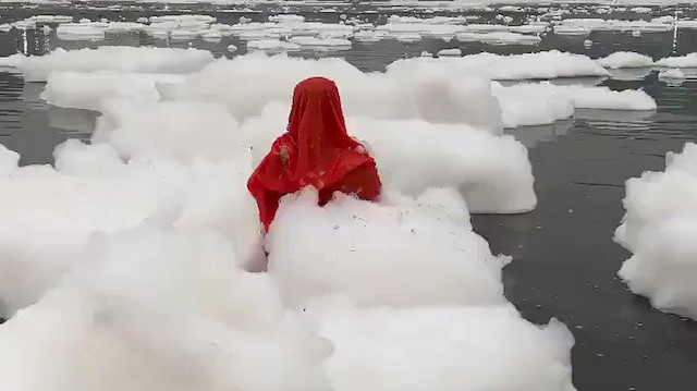 Hindistanda zehirli köpükler içindeki nehirde bir kadın dua etti