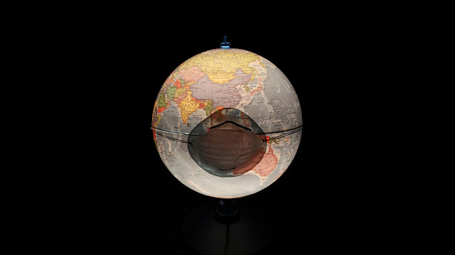 File photo: A protective mask, which is widely used as a preventive measure against the coronavirus (COVID-19), is pictured on a table world globe in this illustration taken March 17, 2020