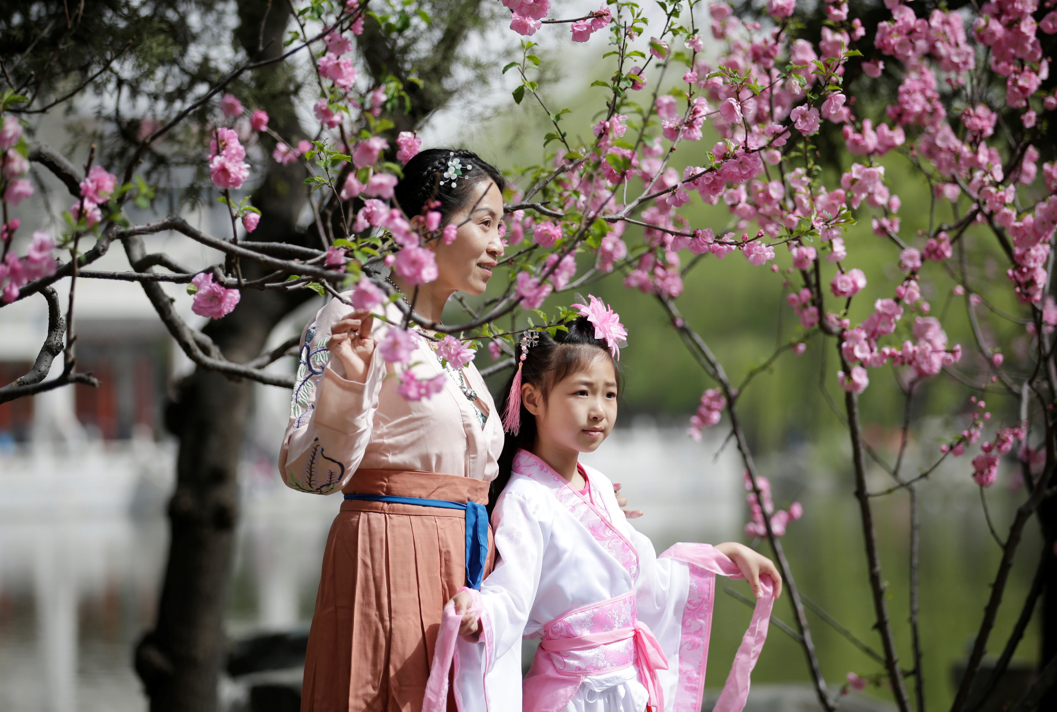 Women dressed in traditional costumes are seen during the Qingming tomb-sweeping festival in Beijing